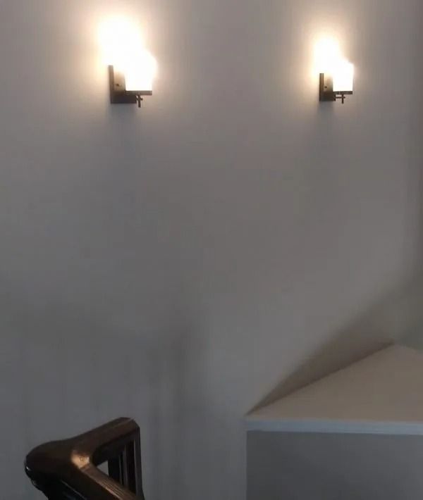 A staircase with two lights on the wall above it