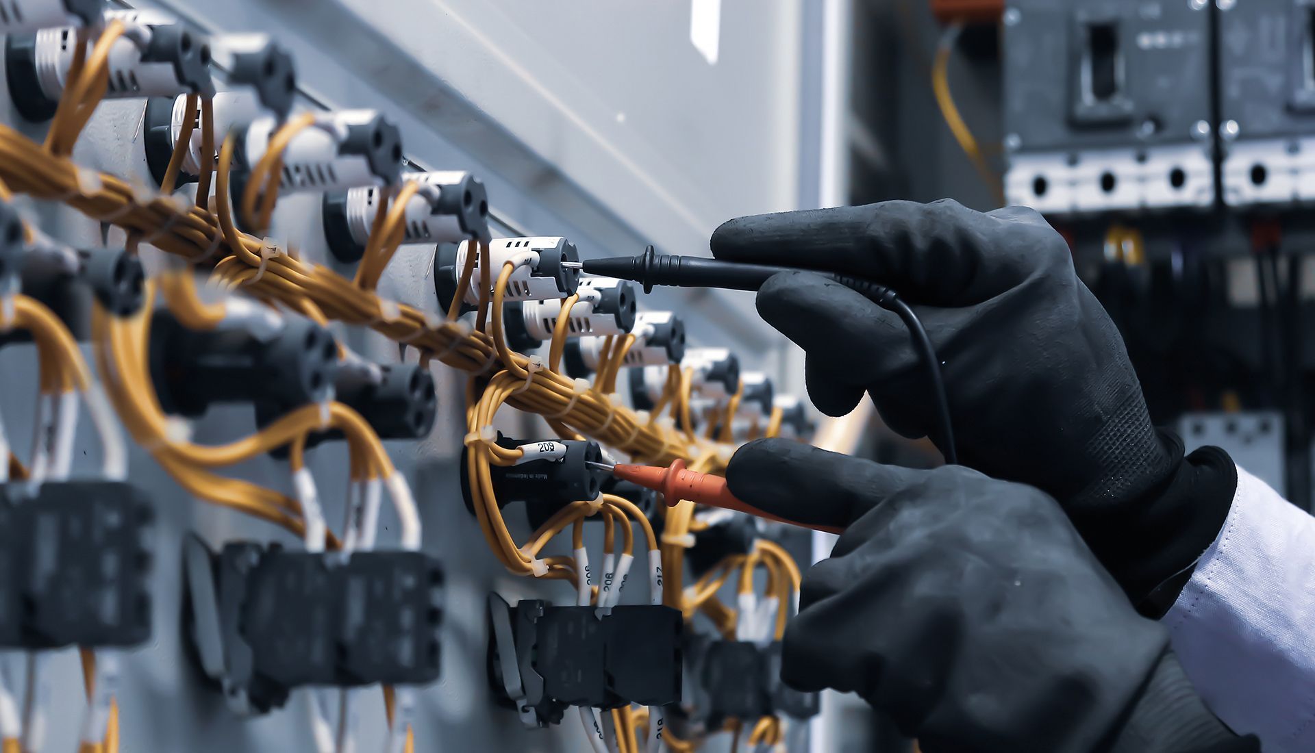 A person is working on an electrical panel with a screwdriver.