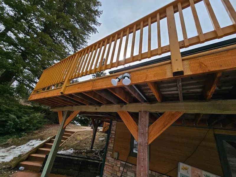 A wooden deck with a yellow railing and lights on it