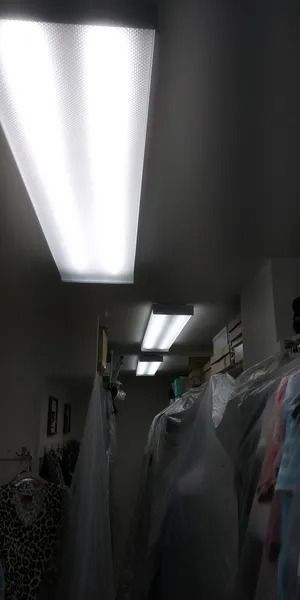 A closet filled with lots of clothes and a light on the ceiling.