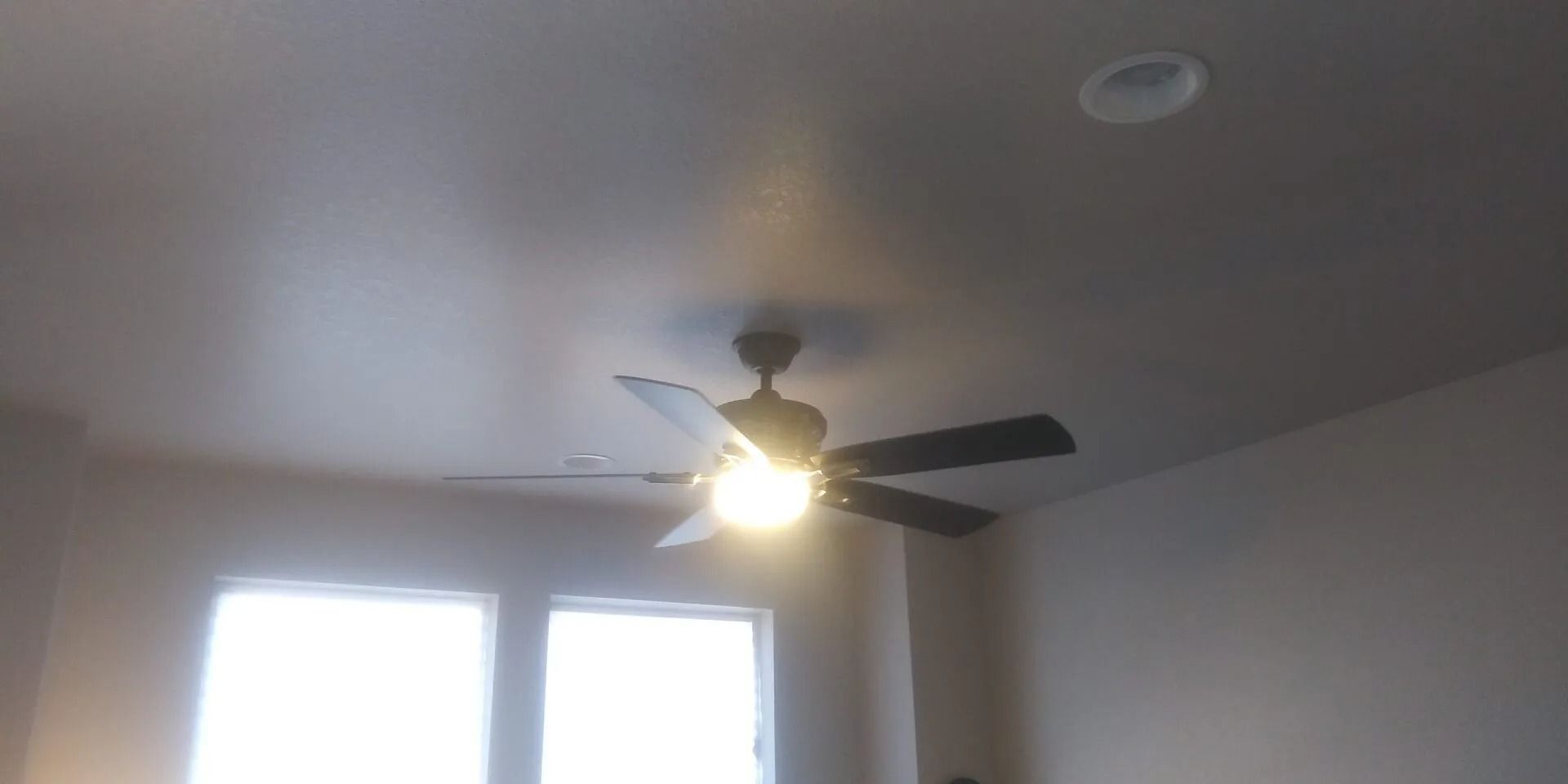 A ceiling fan is hanging from the ceiling of a room.