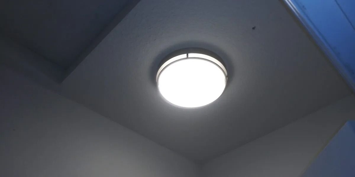 A ceiling light is lit up in a dark room