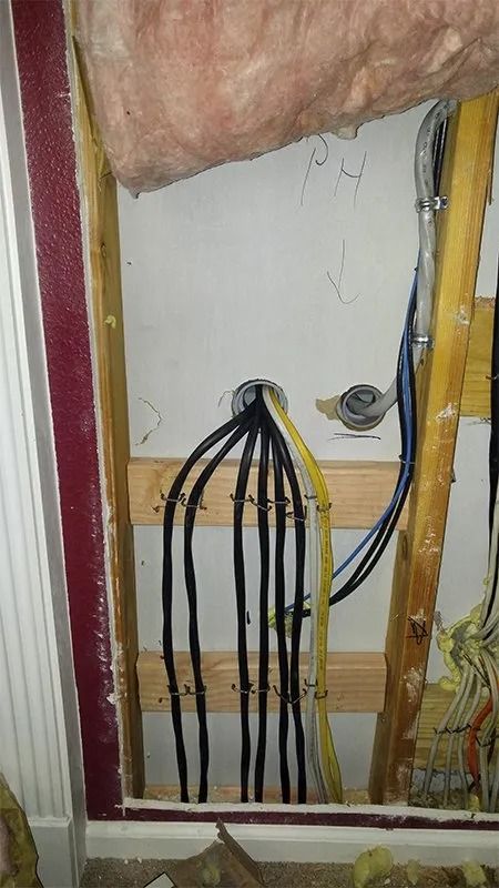 A bunch of wires are hanging from a wall in a room.