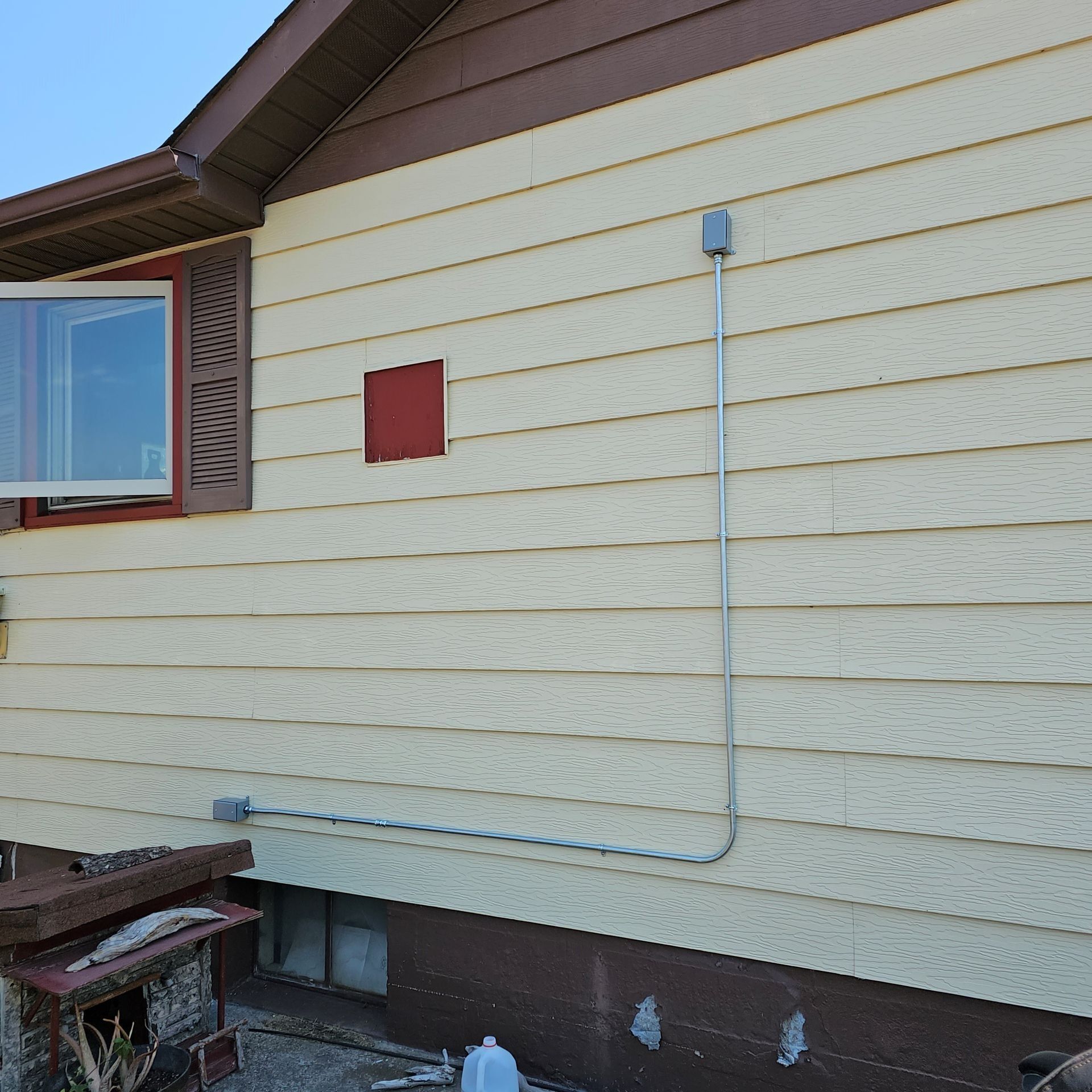 A yellow house with a red square on the side