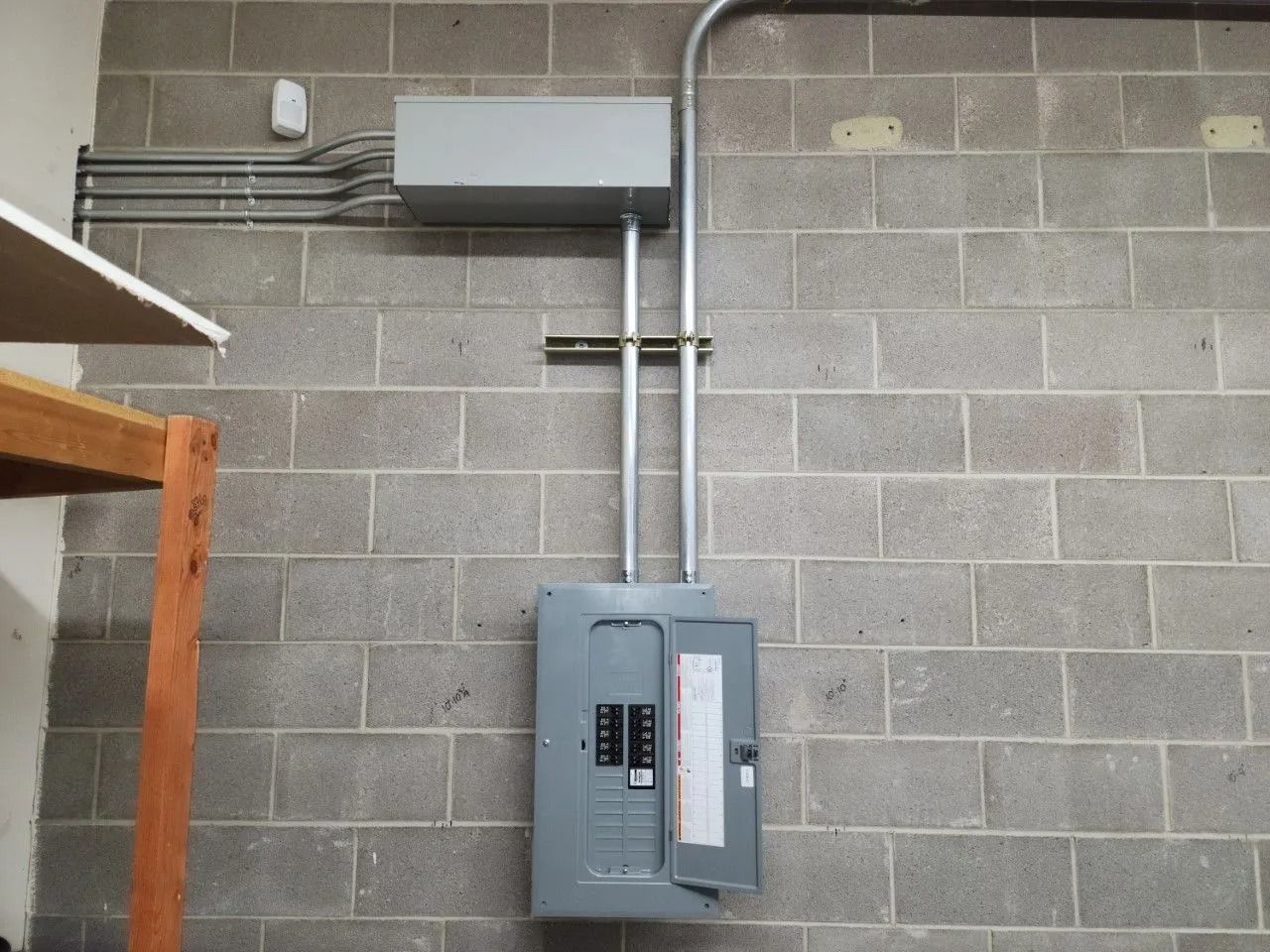 An electrical box is mounted to a brick wall