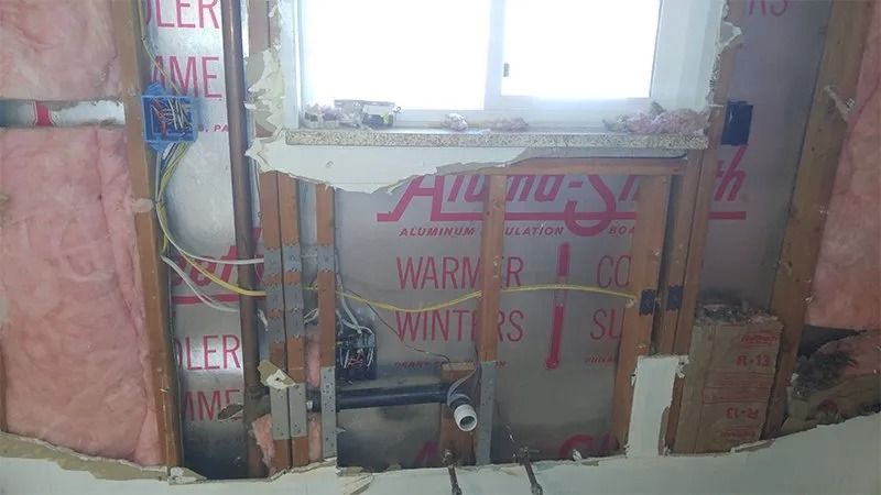 A room with a hole in the wall and a window.