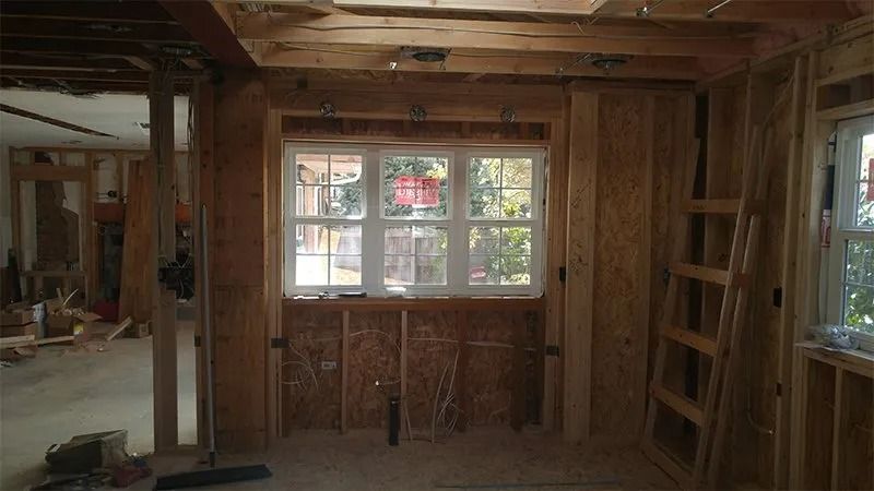 A room under construction with a window and a ladder.