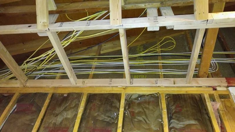 A wooden structure with a lot of wires hanging from it.