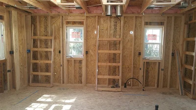 A room with wooden walls and a ladder in it.