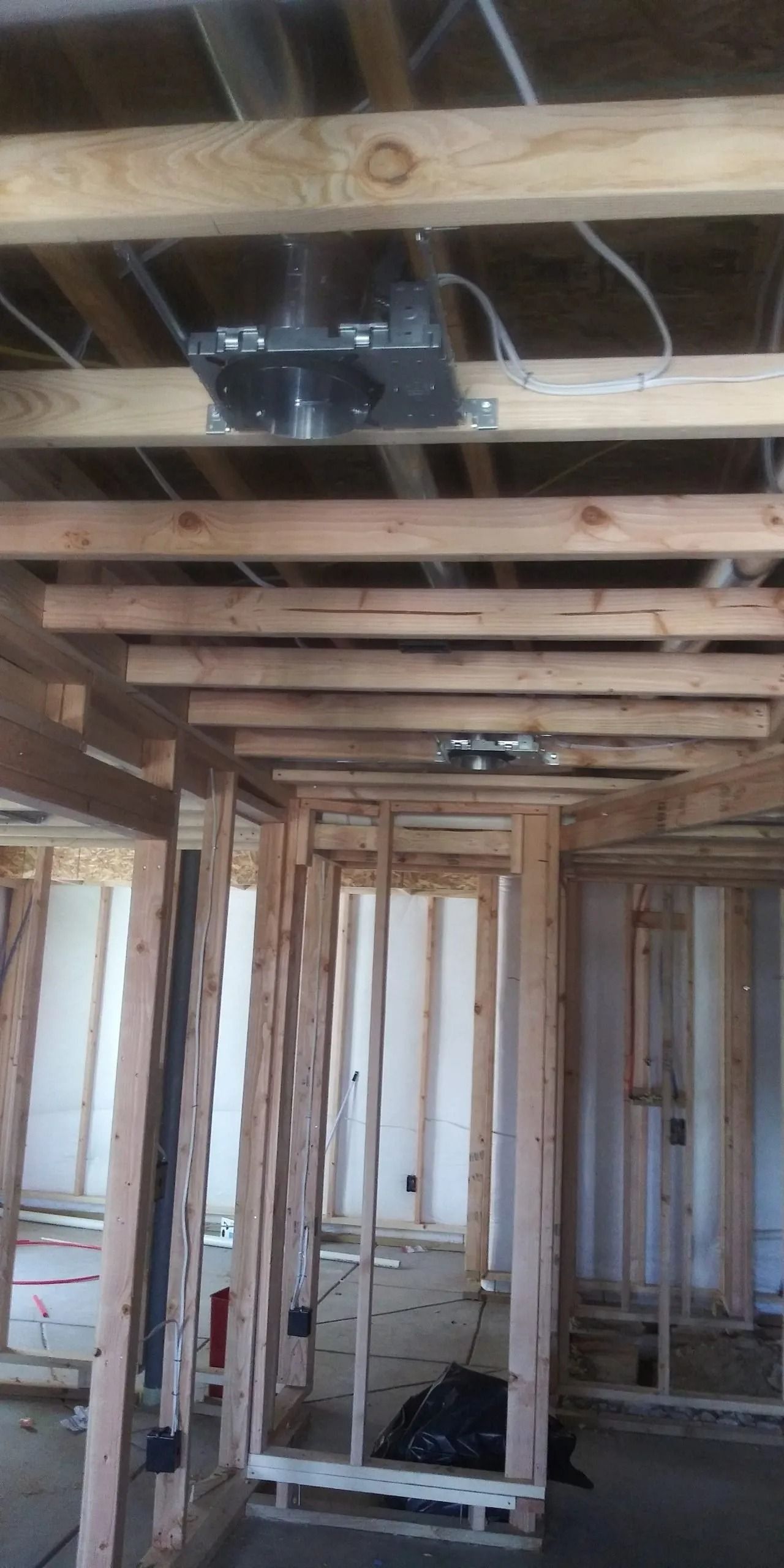 A house is being built with wooden beams and a ceiling fan.