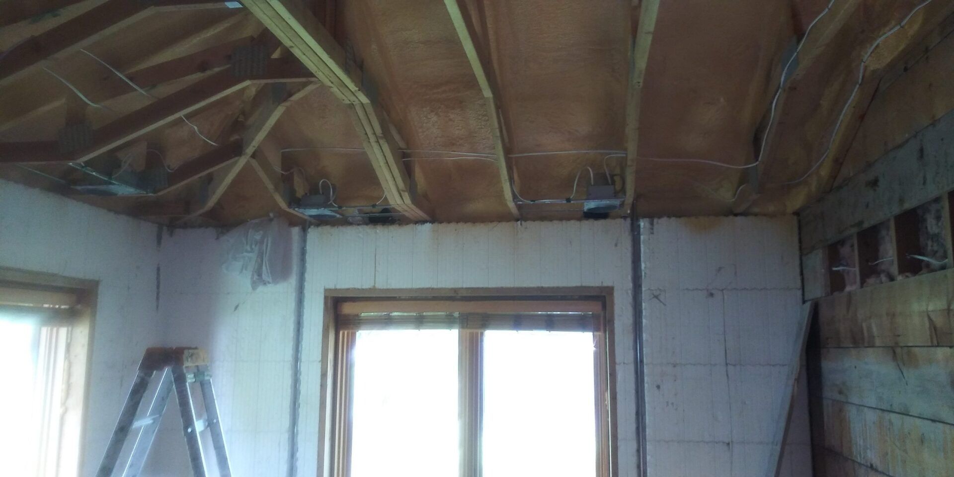 A room with a ladder and a window in it.