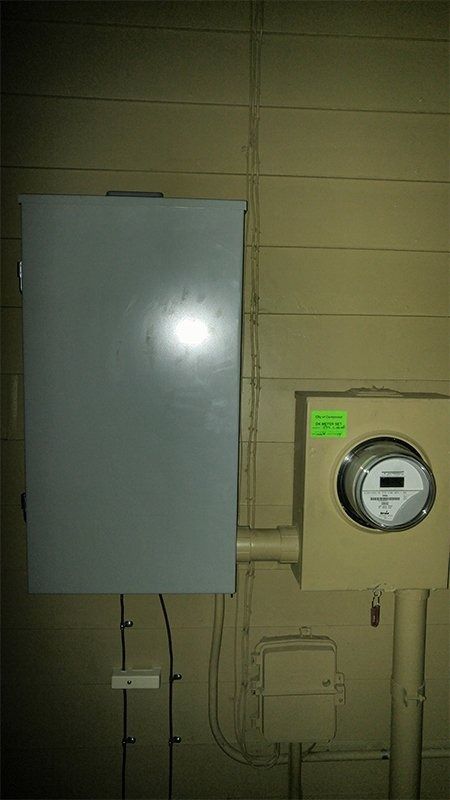 There is a meter on the wall next to a box.