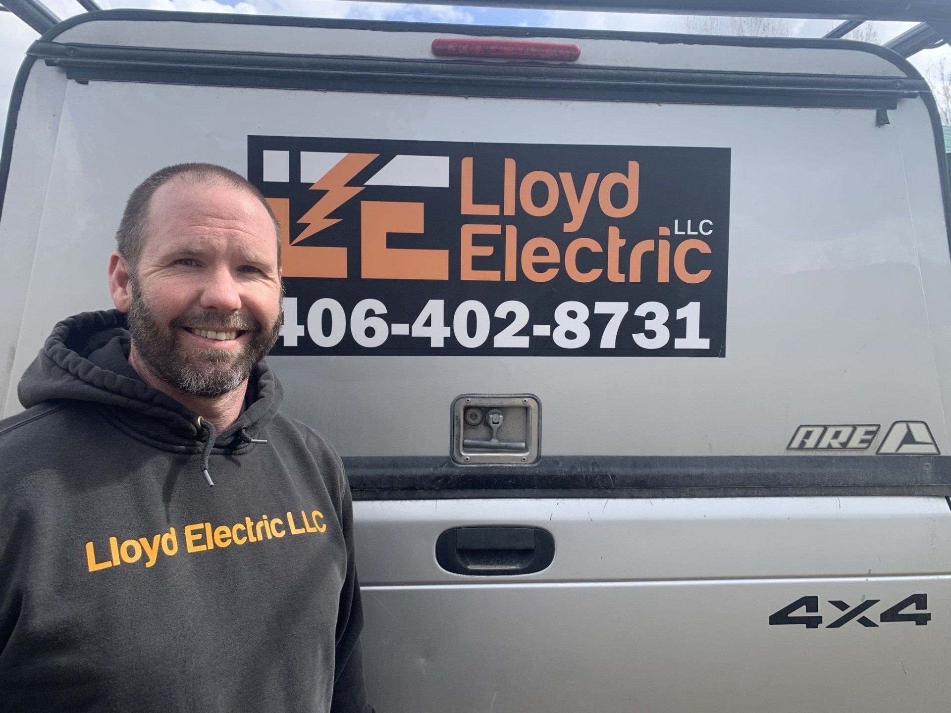 A man is standing in front of a lloyd electric van.