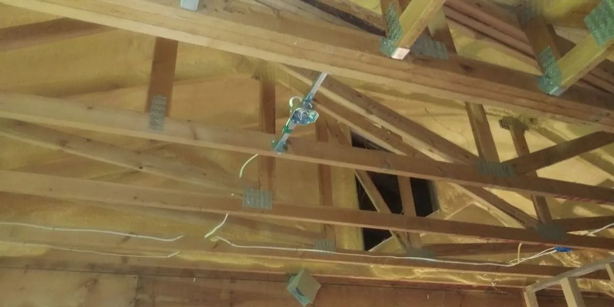 The ceiling of a building under construction with wooden beams.