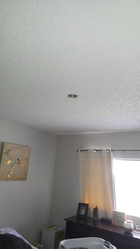 A living room with a white ceiling and a window.