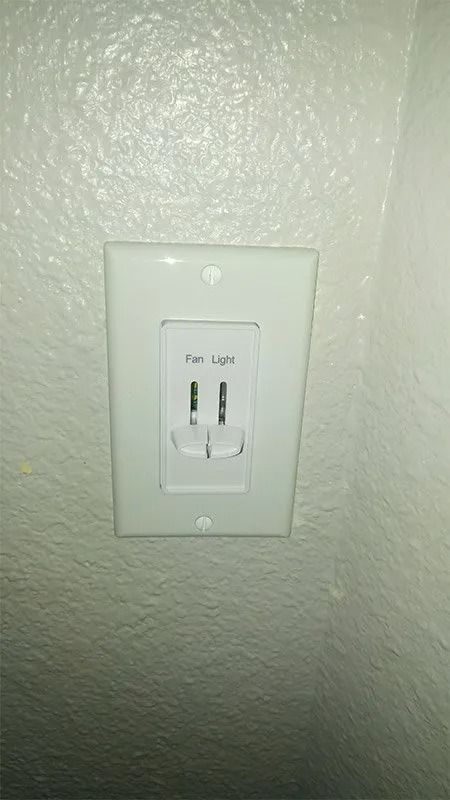 A white electrical outlet is mounted on a white wall.