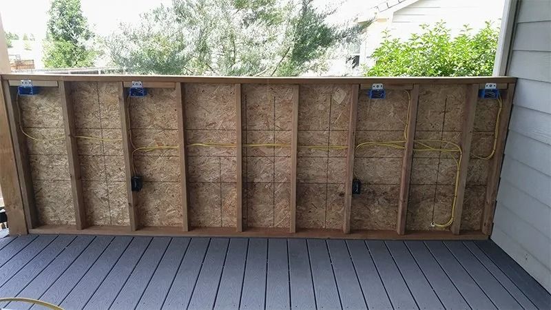 A wooden wall is sitting on top of a wooden deck.