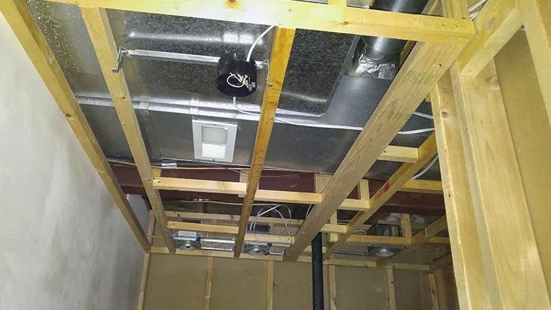A room with a ceiling made of wood and metal pipes.