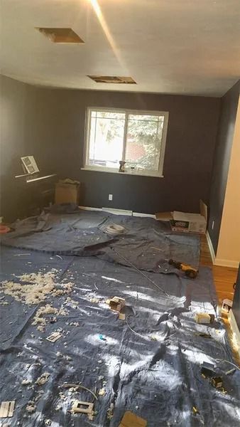 A room with a lot of paint on the floor and a window.