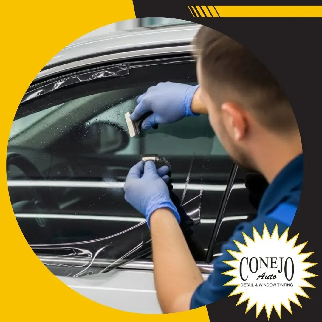 Technician in blue gloves repairing a car window with a suction tool at a Conejo Auto shop