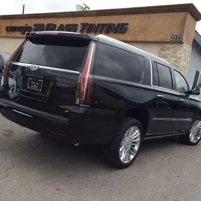 Black Cadillac Escalade parked outside a window tinting shop