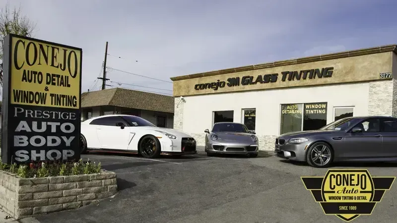 Conejo Auto Window Prestige Body Shop with three sports cars parked outside