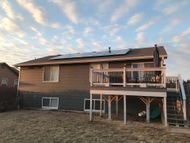 A house with a deck and solar panels on the roof.