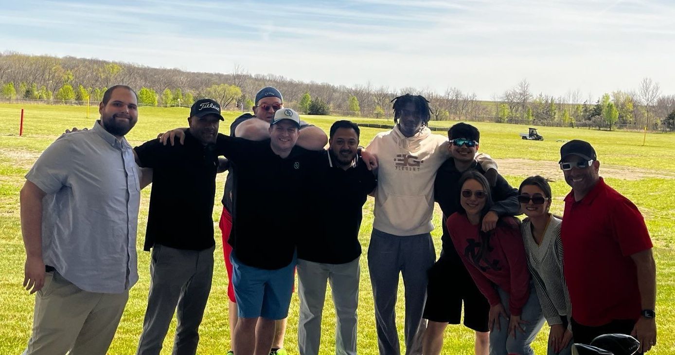 Best solar team is posing for a picture on a golf course.