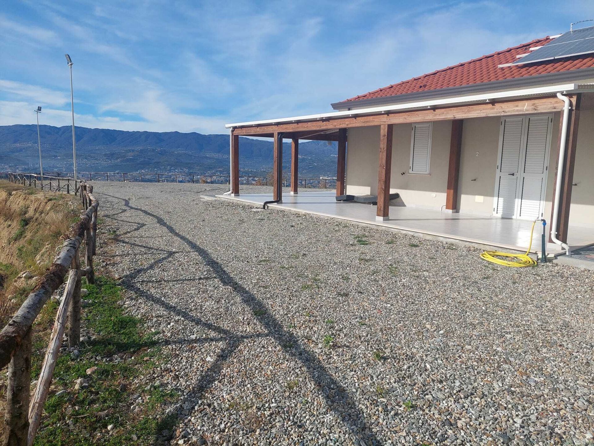 Un vialetto di ghiaia conduce a una casa con il tetto rosso