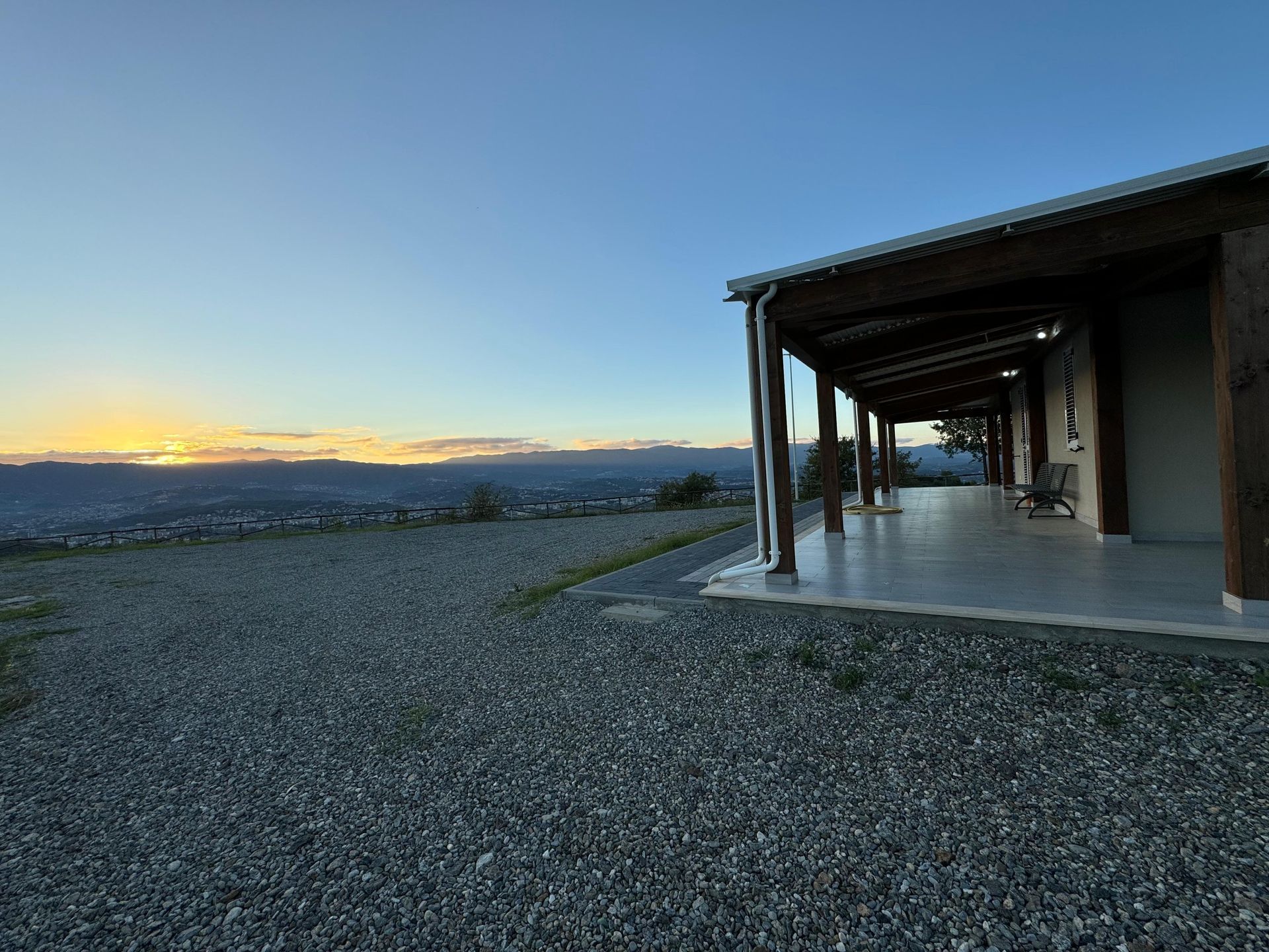 Una casa con un portico e un tramonto sullo sfondo
