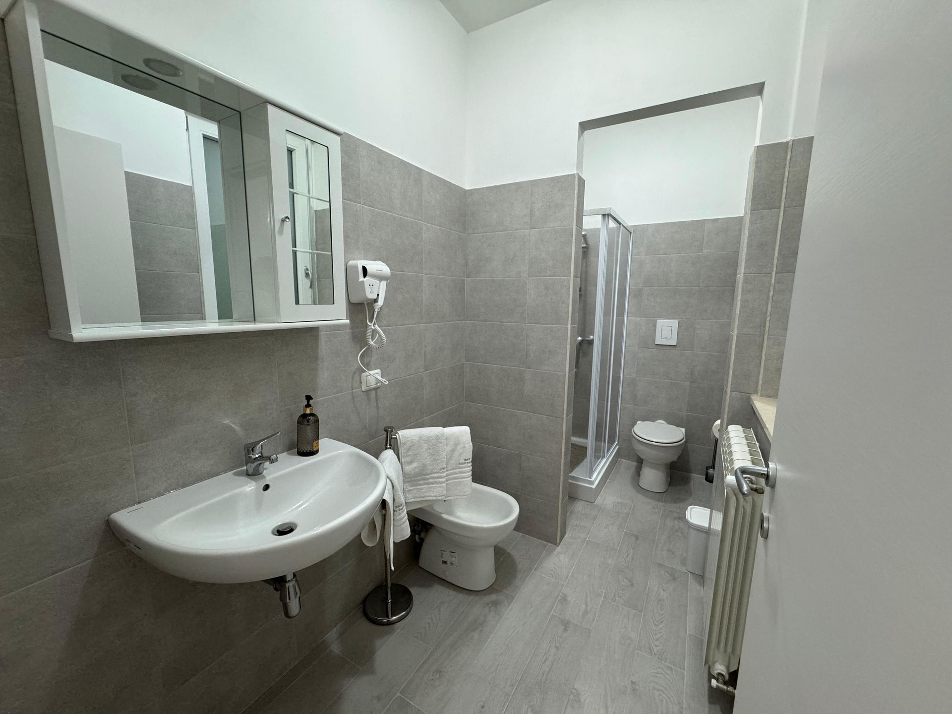 Un bagno con lavandino, wc e doccia