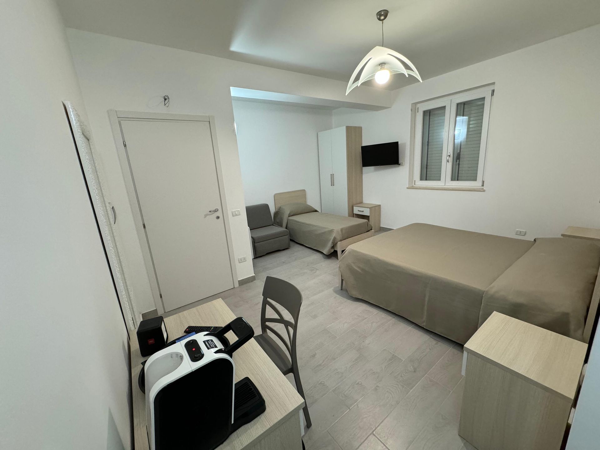 Una camera d'albergo con un letto king size e due letti singoli