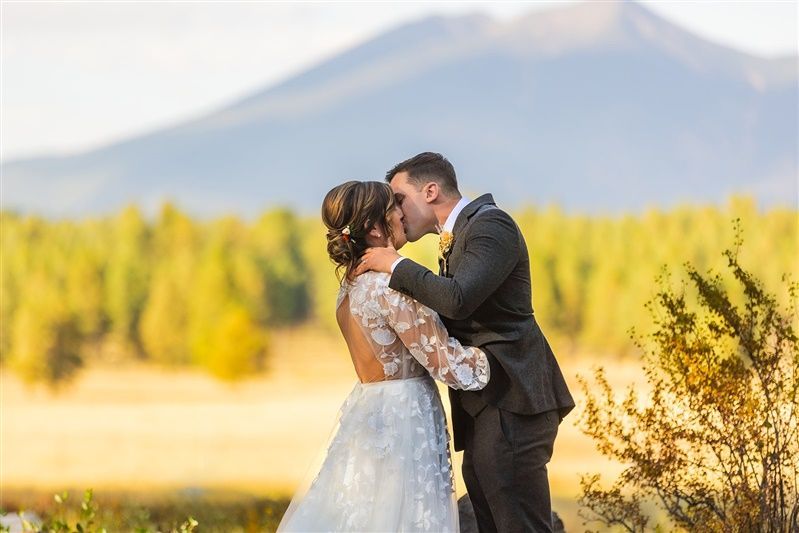 A couple kissing with the San Francisco Peaks behind them