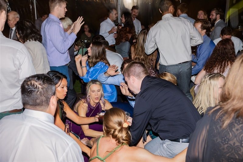 A group of wedding guests having an amazing time on the dance floor.