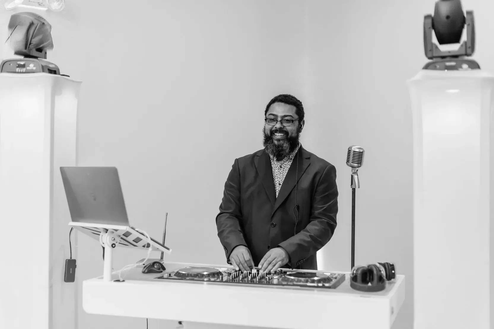 A black and white photo of a man playing a dj set.