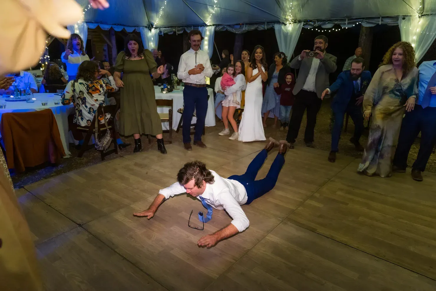 A group of people are dancing together at a wedding reception.