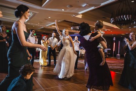 A group of people are dancing on a dance floor at a wedding reception.