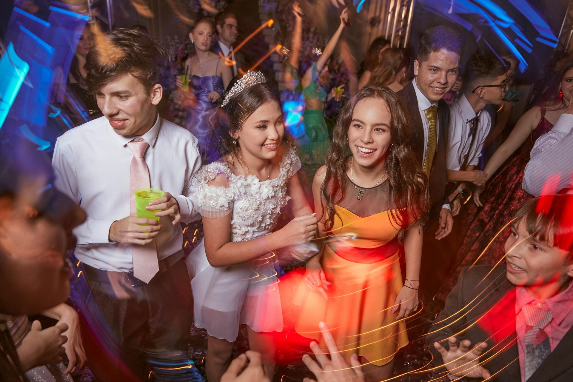 A group of people are dancing at a party in a club.