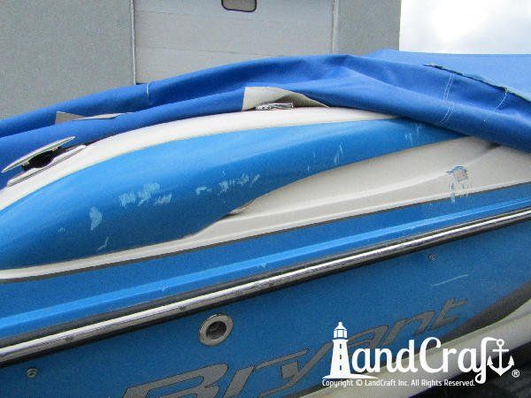 Accident damage along the side of a fiberglass Bryant boat