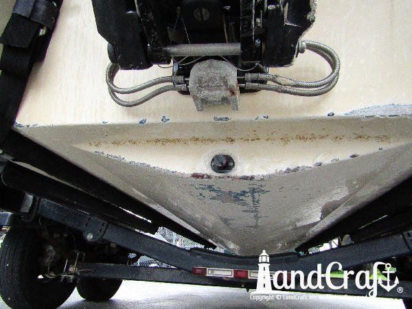Grounding damage along the bottom of a fiberglass Bryant boat