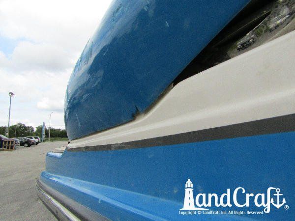 Accident damage along the side of a fiberglass Bryant boat
