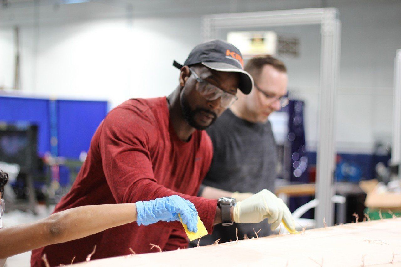 Charles is applying materials to the Row4Kids boat