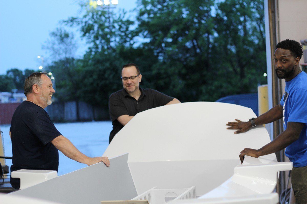 Keith Lekberg discusses the Row4Kids boat with Charles Tillman and Jake Beckley