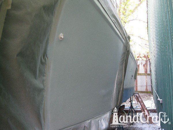 Commercial vessel with hull side in the gelcoat refinishing process