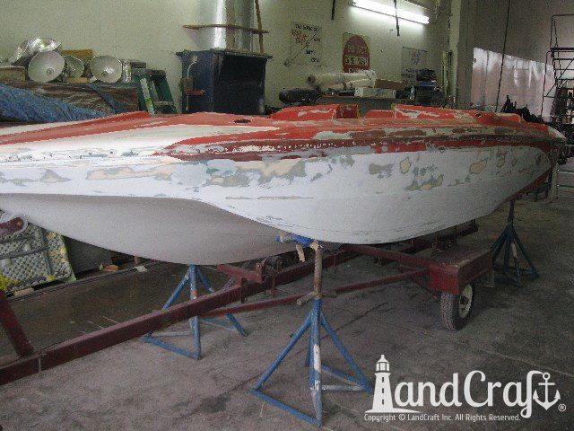 Glastron boat on stands and ready for exterior repairs and refinishing work