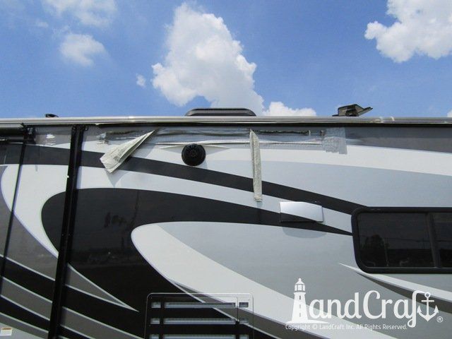 Forest River RV with side damage and tear punctured through due to an accident