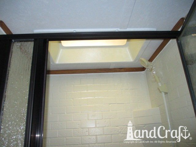 Forest River RV with custom teak finish work above repaired bathroom enclosure