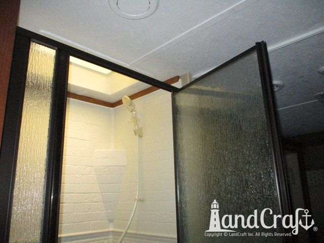 Forest River RV with custom teak finish work above repaired bathroom enclosure