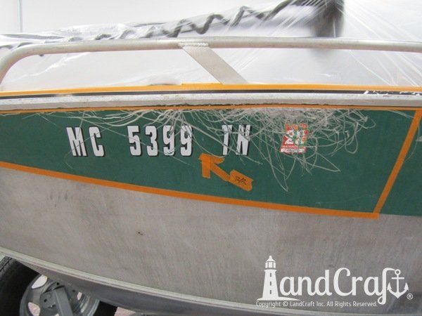 Picture of scratches on the side and rubrail of an aluminum Hewescraft boat