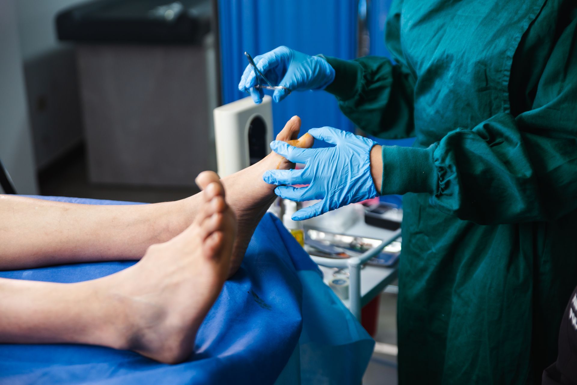 Podiatric care exam with doctor wearing gloves inspecting patient’s foot on medical chair.